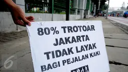 Salah satu tulisan yang dikampanyekan oleh anggota Pramuka yang tergabung dalam Askara saat melakukan aksi peduli pedestrian di sekitar Jalan Medan Merdeka Timur, Jakarta, Jumat (17/3). (Liputan6.com/Helmi Fithriansyah)