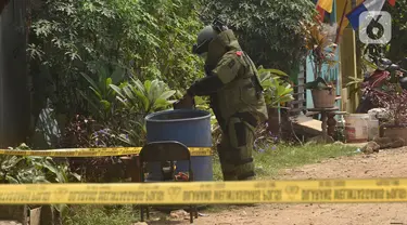 Tim penjinak bom sedang memeriksa tong sampah di Kawasan Caman, Bekasi, Jawa Barat, Senin (23/8/2021). Benda mencurigakan tersebut menyerupai bom tetapi tidak mengandung bahan peledak. (Liputan6.com/Herman Zakharia)