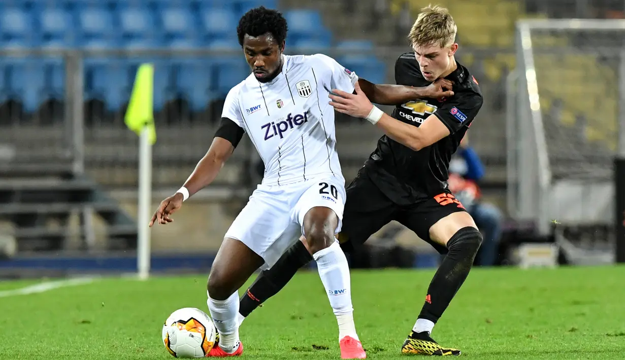 Pemain LASK Linz Samuel Tetteh (kiri) berebut bola dengan pemain Manchester United (MU) Brandon Williams pada leg pertama babak 16 besar Liga Europa di Linz, Austria, Kamis (12/3/2020). MU menang 5-0. (AP Photo/Kerstin Joensson)