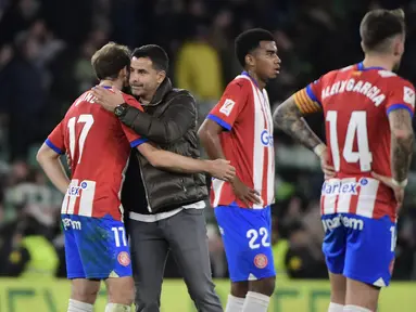 Pelatih Girona Michel menyemangati anak asuhnya Daley Blind pada akhir laga pekan 18 Liga Spanyol 2023/2024 melawan Real Betis di Stadion Benito Villamarin, Jumat (22/12/2023) dinihari WIB. (CRISTINA QUICLER / AFP)