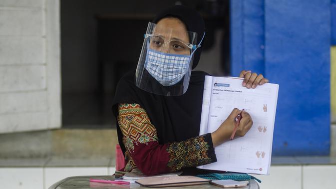 Guru mengenakan masker saat mengajar siswa SD secara tatap muka di Sekolah Islam Ibnu Aqil Ibnu Sina, Soreang, Bandung, Jawa Barat, Rabu (5/8/2020). Indonesia akan mengizinkan sekolah di zona hijau COVID-19 melakukan pembelajaran tatap muka di bawah protokol kesehatan yang ketat. (Xinhua/Septianjar)