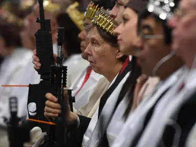 Seorang wanita lansia mengenakan mahkota dari selongsong peluru sambil memegang senapan AR-15 saat menghadiri upacara di Newfoundland, Pennsylvania (28/2). Dalam upacara ini para jemaah membawa senjata. (AFP/Don Emmert)
