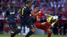 Striker Bayern Munchen, Robert Lewandowski, berebut bola dengan pemain Koln, Rafael Czichos, pada laga Bundesliga di Allianz Arena, Sabtu (21/9/2019). Bayern Munchen menang 4-0 atas Koln. (AP/Matthias Schrader)