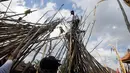Seorang pria berada diatas puncak tongkat saat ritual Mekotek di Bali (11/11). Peserta yang terkena pukulan tongkat harus merelakan dirinya untuk naik ke kumpulan tongkat dari para peserta yang lain. (AP Photo/Firdia Lisnawati)