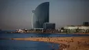 Orang-orang menikmati pantai di Barcelona, Spanyol, Rabu, (20/5/2020). Barcelona mengizinkan orang untuk berjalan di pantai Rabu, untuk pertama kalinya sejak dimulainya penutupan virus lebih dari dua bulan lalu. Berjemur dan berenang rekreasi masih tidak diizinkan. (AP Photo/Emilio Morenatti)