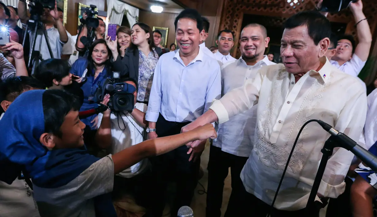 Presiden Filipina Rodrigo Duterte melakukan tos dengan bocah yang diculik oleh kelompok Abu Sayyaf di Istana Malacanang, Manila, Filipina, Selasa (28/2). (AP Photo)