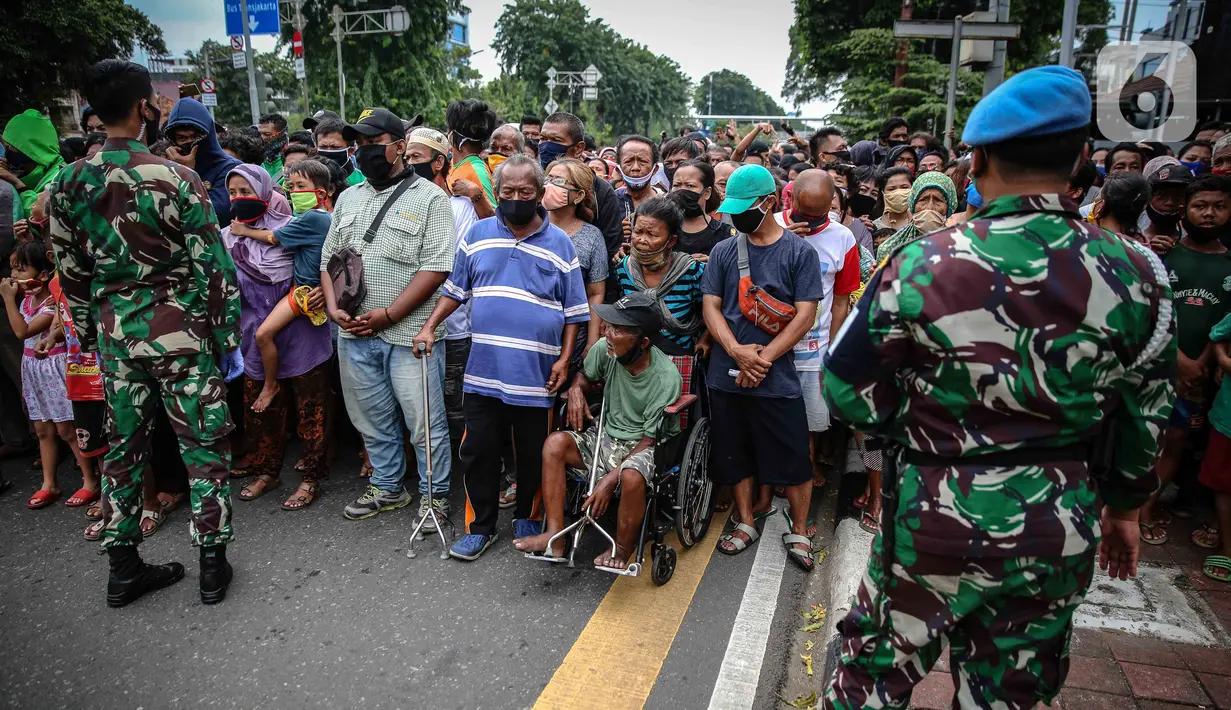 Warga mengantre nasi kotak serta masker dari TNI di Markas Komando Gabungan Wilayah I, Jakarta, Selasa (21/4/2020). Dalam rangka Hari Kartini, TNI membagikan makanan dan masker kepada masyarakat. (Liputan6.com/Faizal Fanani)
