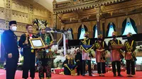 Menpora Zainuddin Amalli menerima penghargaan dari Rektor Unesa. (Dian Kurniawan/Liputan6,com)