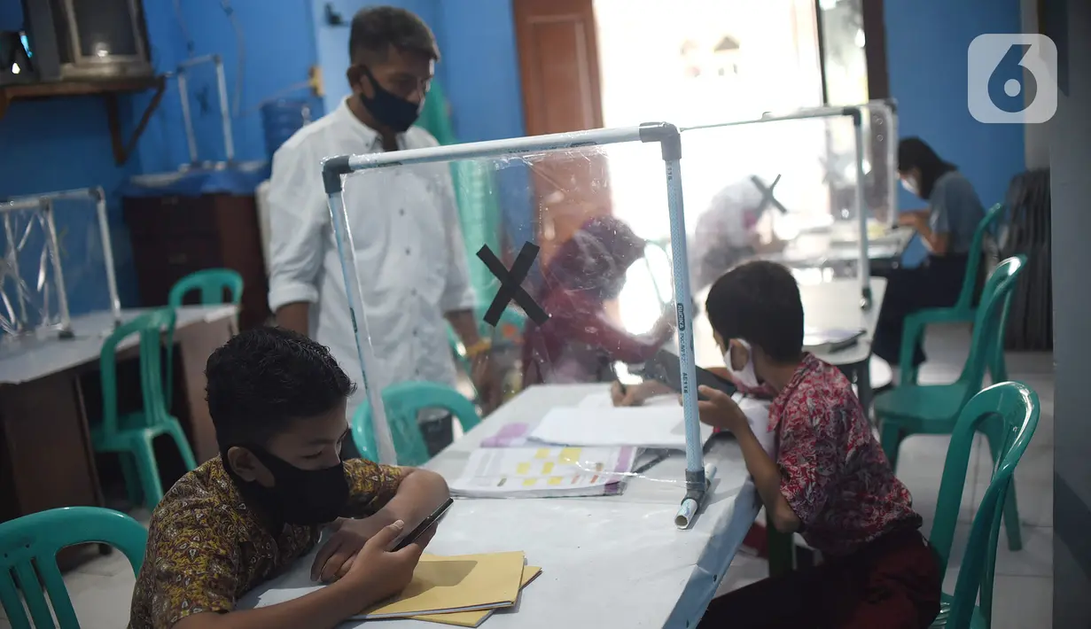 Sejumlah siswa mengikuti PJJ di Balai Warga RT 05/RW 02 Kelurahan Galur, Johar Baru, Jakarta, Selasa (15/8/2020). Program Internet Gratis untuk semua yang digalakan Pemprov DKI Jakarta diharapkan bisa membantu para siswa SD, SMP dan SMA selama pandemi Covid-19. (Liputan6.com/Fery Pradolo)
