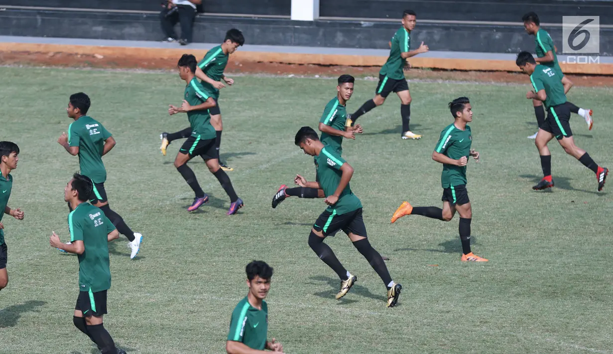 Pemain Timnas Indonesia U-19 melakukan lari pemanasan saat latihan di Lapangan B Kompleks GBK, Jakarta, Selasa (18/9). Latihan ini persiapan  PSSI Anniversary Cup U-19 dan Piala AFC U19. (Liputan6.com/Helmi Fithriansyah)