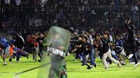 Suporter memasuki lapangan saat terjadi kerusuhan pada pertandingan sepak bola antara Arema Vs Persebaya di Stadion Kanjuruhan, Malang, Jawa Timur, 1 Oktober 2022. Kapolda Jawa Timur Irjen Pol Nico Afinta dalam jumpa pers di Kabupaten Malang, Jawa Timur, Minggu, mengatakan dari 127 orang yang meninggal dunia tersebut, dua di antaranya merupakan anggota Polri. (AP Photo/Yudha Prabowo)