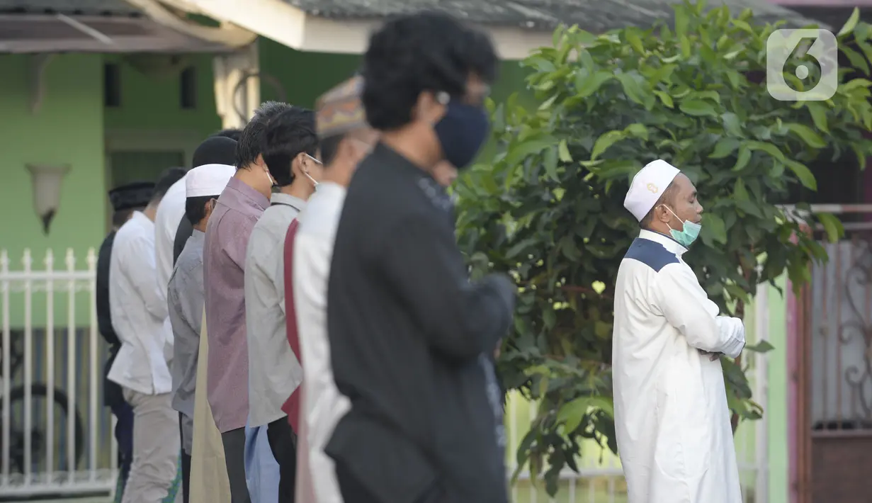 Jemaah melaksanakan salat Idul Fitri di pelataran Masjid Al Kahfi Griya Pamulang 2, Parakan, Pamulang, Tangerang Selatan, Banten, Minggu (24/5/2020). Di tengah pandemi virus corona COVID-19, jemaah yang hadir mengenakan masker untuk mencegah penularan. (merdeka.com/Dwi Narwoko)