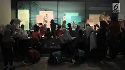 Rombongan siswa SD melihat informasi sejarah manusia purba di Museum Nasional, Jakarta, Selasa (26/6). Merayakan ulang tahun Jakarta ke-491, Pemprov DKI menggratiskan tiket masuk museum-museum yang berada di Jakarta. (Merdeka.com/ Iqbal S. Nugroho)