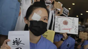 Seorang perawat mengenakan penutup mata dan masker mengambil bagian dalam protes terhadap kebrutalan polisi terhadap para pengunjuk rasa di sebuah rumah sakit di Hong Kong (13/8/2019). (AP Photo/Kin Cheung)