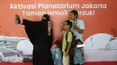 Pengunjung berswafoto sebelum memasuki area Planetarium di Taman Ismail Marzuki, Jakarta, Kamis (25/12/2025). Planetarium Taman Ismail Marzuki (TIM) akhirnya dibuka kembali. Planetarium Taman Ismail Marzuki (TIM) akhirnya dibuka kembali. (Kapanlagi.com/Budy Santoso)
