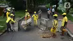 Petugas gabungan memindahkan beton pembatas dengan alat berat di Jalur Inspeksi Kanal Banjir Timur (KBT), Cipinang, Jakarta Timur, Kamis (30/12/2021). Kawasan KBT ditutup guna mencegah kerumunan warga yang hendak merayakan malam pergantian tahun. (merdeka.com/Imam Buhori)