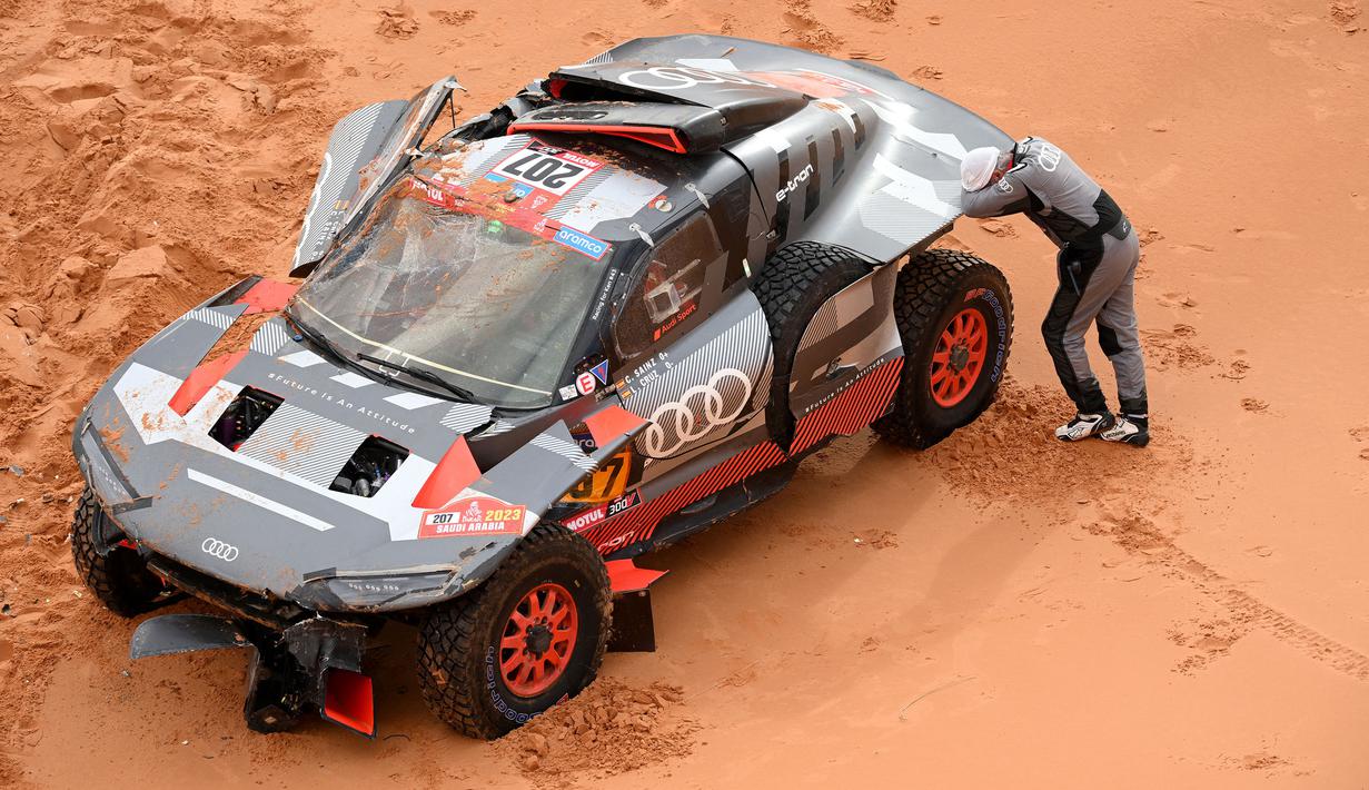 Carlos Sainz terpaksa mundur dari Reli Dakar 2023 setelah mengalami insiden parah di stage 9 yang berlangsung dari Riyadh hingga Haradh pada Selasa (10/01/2023) waktu setempat. (AFP/Franck Fife)