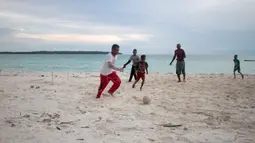 Sore hari menjadi pilihan untuk bermain bola dekat pantai di Desa Matwaer, Kei Kecil, Maluku (25/12/2017). Bermain bola di pasir menjadi daya tarik tersendiri bagi anak-anak dan pemuda desa. (Bola.com/Nick Hanoatubun)