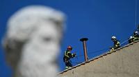 Jelang konklaf, petugas pemadam kebakaran memasang cerobong asap di atap Kapel Sistina di Kota Vatikan, pada Jumat (2/5/2025). (Dok. AFP/Gabriel Bouys)