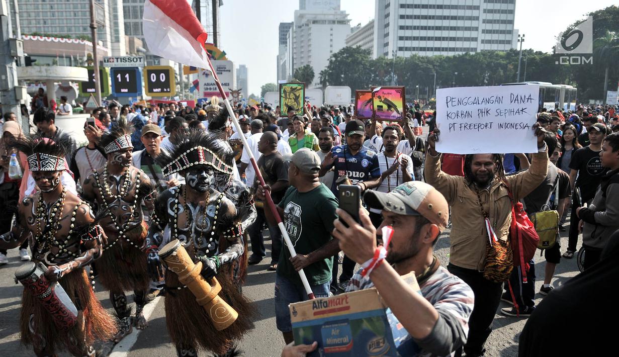 Masyarakat Papua yang merupakan mantan karyawan PT Freeport Indonesia saat melakukan penggalangan dana di tengah berlangsungnya Hari Bebas Kendaraan Bermotor atau Car Free Day di kawasan Bundaran HI, Jakarta, Minggu (5/8). (Merdeka.com/Iqbal S. Nugroho)