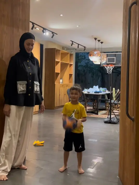 Menemani sang anak bermain, Paula tampil dengan kerudung hitam dipadukan atasan kemeja hitam lengan panjang memiliki aksen kantong depan serta bawahan celana panjang putih. [@paula_verhoeven]