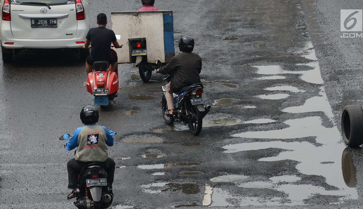 Sejumlah kendaraan melewati jalan berlubang yang masih tergenang air di ruas Jalan Lapangan Ros, Tebet, Jakarta, Sabtu (11/5/2019). Jalan-jalan berlubang yang terisi air tersebut dapat mengakibatkan kecelakaan bagi pengendara kendaraan bermotor. (merdeka.com/Imam Buhori)