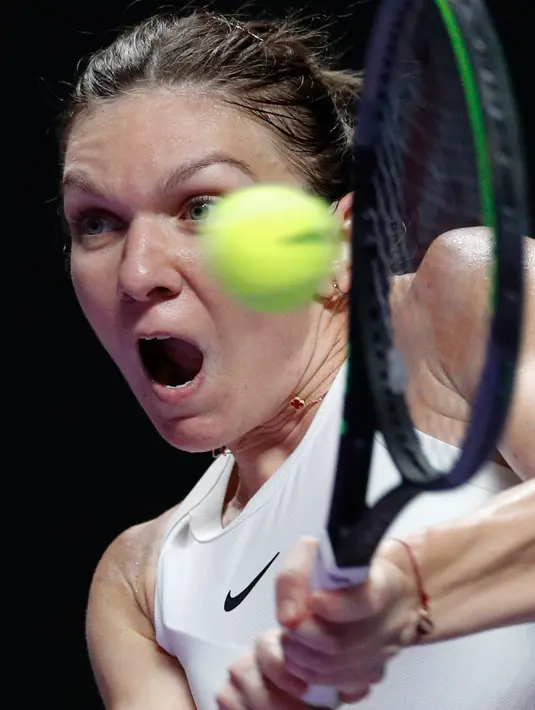 Petenis Rumania, Simona Halep berusaha mengembalikan bola ke petenis Kanada, Bianca Andreescu selama turnamen WTA Finals 2019 di Shenzhen, China, Senin (28/10/2019). Juara Wimbledon musim ini, Simona Halep merebut kemenangan 3-6, 7-6, 6-3 dalam waktu 2 jam 34 menit atas Andreescu. (AP/Andy Wong)