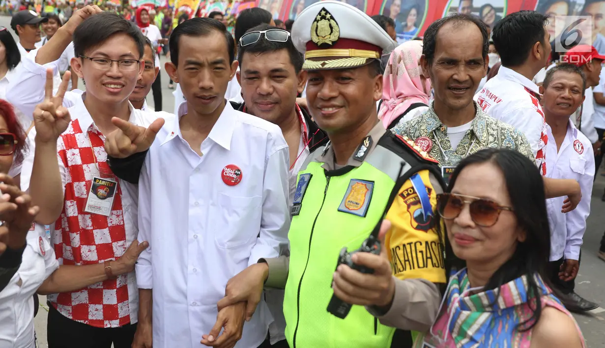 Warga berebut foto bersama seorang pria berwajah mirip Presiden Joko Widodo (Jokowi) di sekitar lokasi akad nikah Kahiyang Ayu dengan Bobby Nasution, Solo, Rabu (8/11). Pria asal Jakarta tersebut bernama Reza Sri Mulyadi. (Liputan6.com/Angga Yuniar)