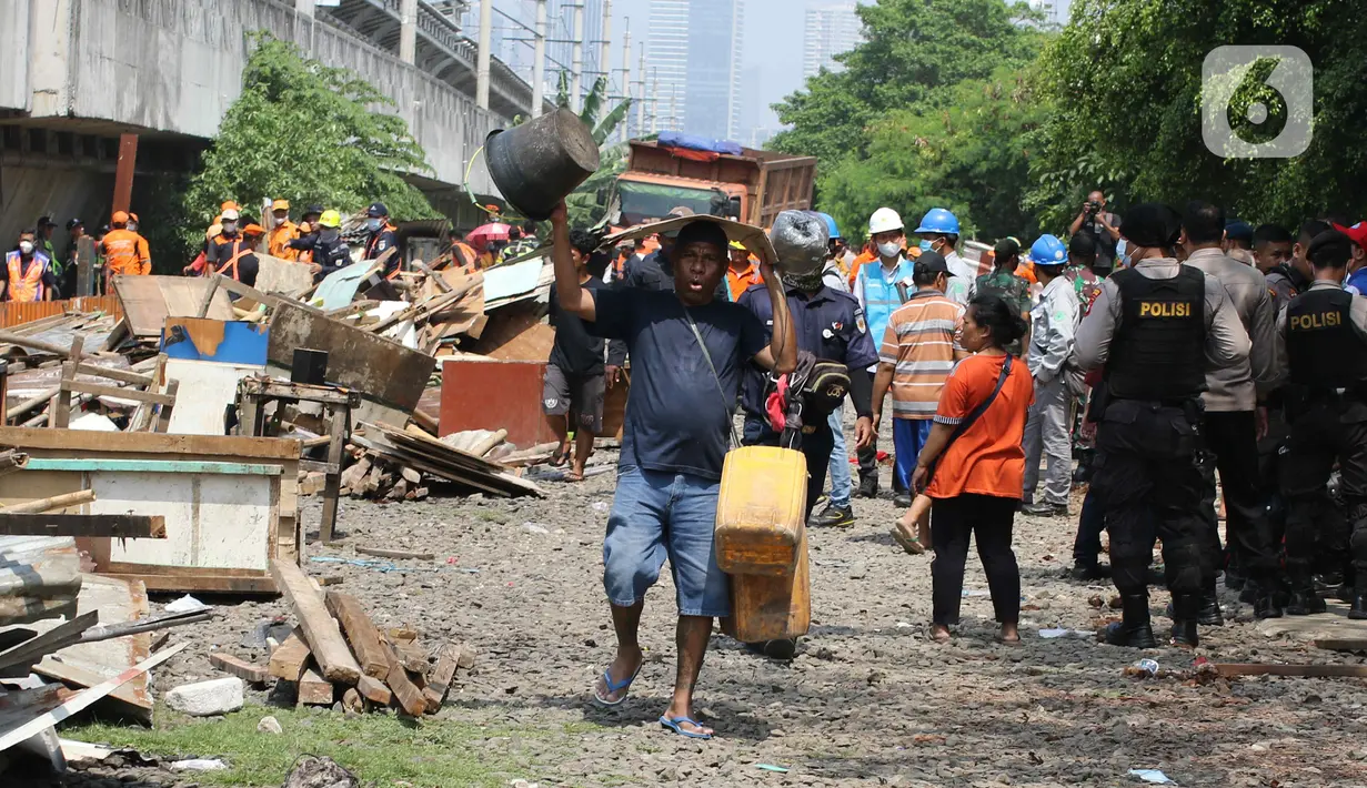 Warga mengangkut barang-barangnya saat penertiban bangunan lokalisasi liar Gunung Antang di Matraman, Jakarta Timur, Selasa (30/8/2022). Sebanyak 120 bangunan liar dibongkar di lahan seluas 2.500 meter persegi milik PT KAI dan selanjutnya akan dijadikan Ruang Terbuka Hijau (RTH). (Liputan6.com/Herman Zakharia)