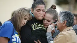 Sejumlah wanita menangis saat melakukan aksi simpatik mengenang korban penembakan di Kampus Umpqua Community College di Roseburg, Sabtu (3/10/2015). Setidaknya 15 orang tewas dalam peristiwa tersebut. (REUTERS / Lucy Nicholson)