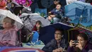 Para penggemar kerajaan Inggris menonton upacara penobatan Raja Charles III dari layar di taman Hyde,  London, Sabtu (6/5/2023). (AP Photo/Emilio Morenatti)