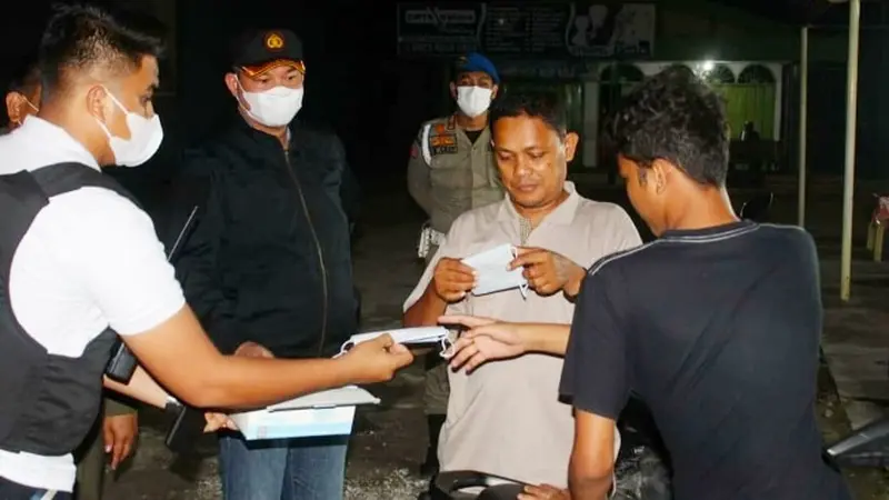Kapolresta Pekanbaru Kombes Nandang memberikan masker kepada warga yang tidak taat protokol kesehatan.