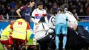 Petugas medis memberikan pertolongan kepada pemain PSG, Kylian Mbappe setelah berbenturan dengan kiper Olympique Lyon, Anthony Lopes dalam lanjutan Ligue 1 di Groupama Stadium, Senin (22/1). Benturan itu membuat Mbappe cedera. (AP/Laurent Cipriani)