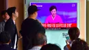 Warga menonton siaran berita televisi yang menampilkan penyiar berita, Ri Chun-Hee saat memberitakan uji coba nuklir di stasiun kereta di Seoul pada 9 September 2016. (AFP Photo/Jung Yeon-Je)