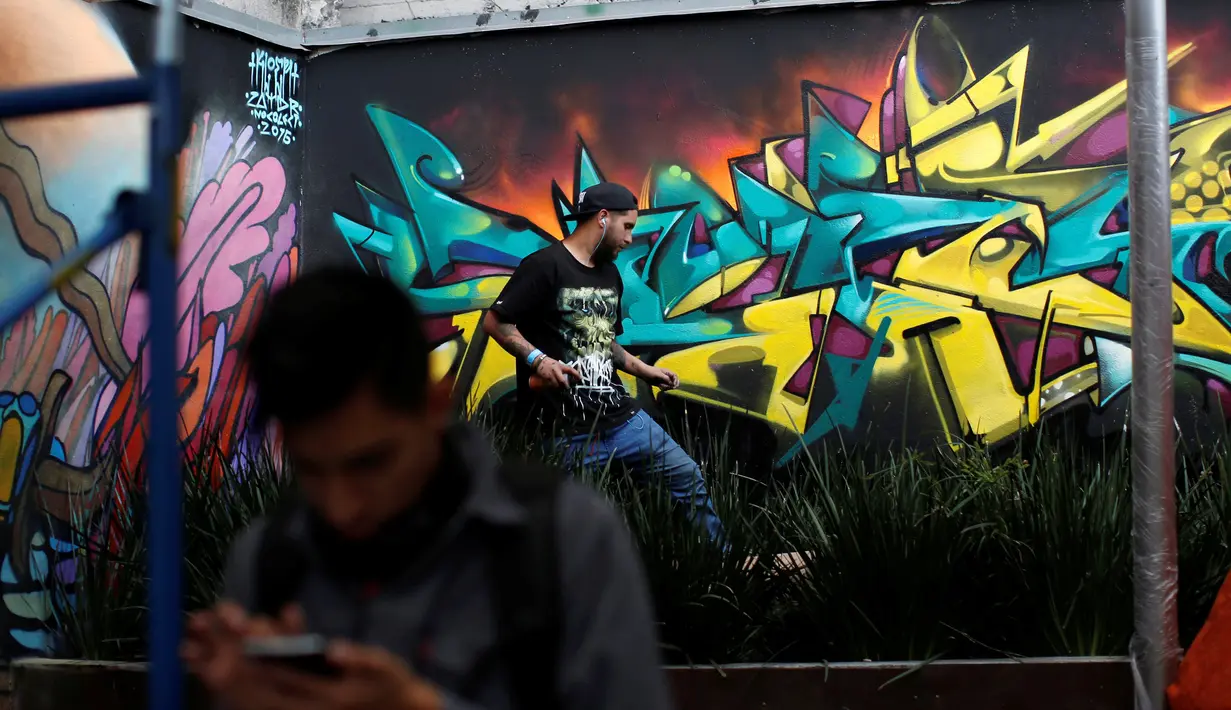 Seniman grafiti menyelesaikan lukisannya selama festival pekan grafiti di Mexico City, Meksiko, Minggu (9/10). Biasanya lewat festival, dapat mengangkat potensi seniman-seniman lokal untuk tampil bersama karya seniman terkenal. (REUTERS/Carlos JASSO)