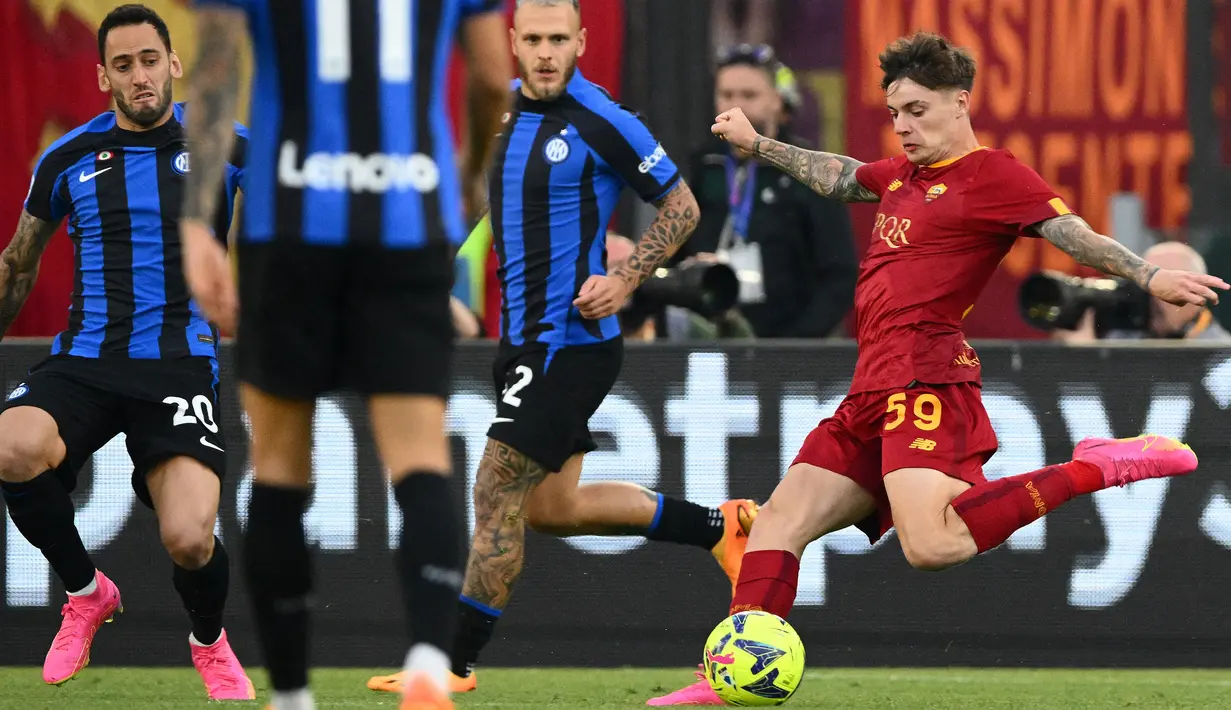 Pemain Inter Milan berusaha menghadang tendangan pemain AS Roma,Nicola Zalewski (kanan), dalam pertandingan lanjutan pekan ke-34 Serie A Liga Italia 2022/2023 yang berlangsung di stadion Olimpico, Sabtu (6/5/2023) malam WIB. (AFP/Vicenzo Pinto)