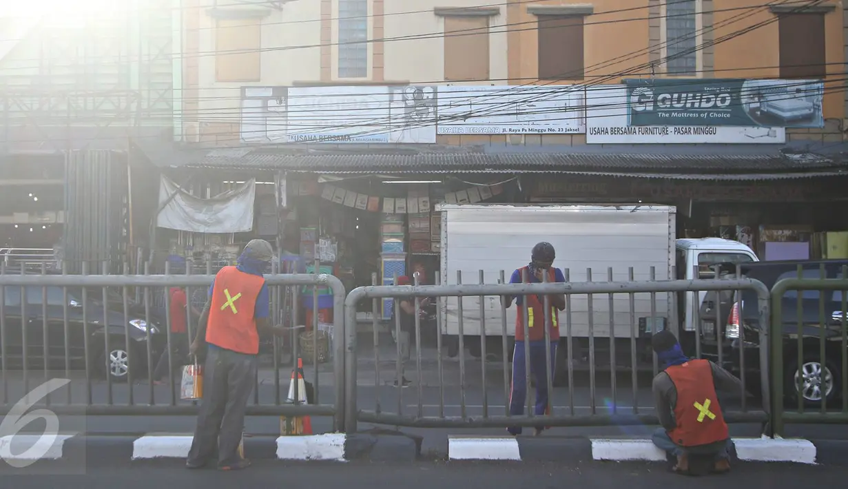 Sejumlah pekerja melakukan pengecatan pembatas jalan di kawasan Pasar Minggu, Jakarta Selatan, Rabu (26/10). Pengecatan dilakukan sebagai bentuk perawatan agar pagar pembatas tetap rapi dan tidak tampak kusam. (Liputan6.com/Immanuel Antonius)
