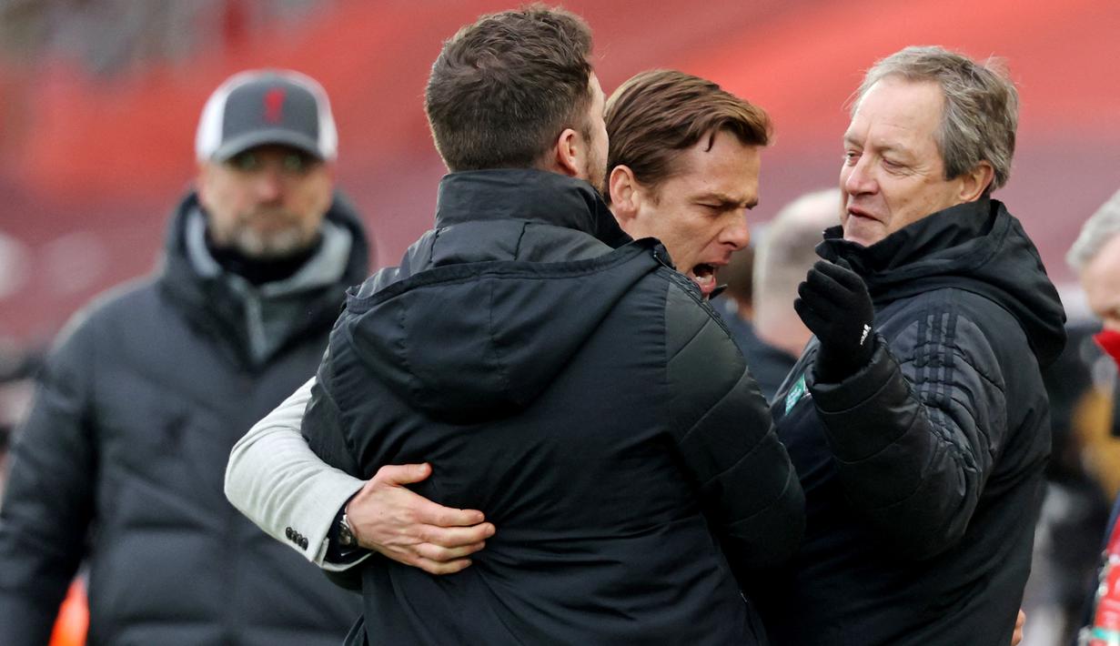 Pelatih Fulham, Scott Parker, merayakan kemenangan bersama stafnya usai anak asuhnya berhasil menaklukkan Liverpool pada laga Liga Inggris di Stadion Anfield, Minggu (7/3/2021). Fulham menang dengan skor 0-1. (Clive Brunskill/Pool/AFP)