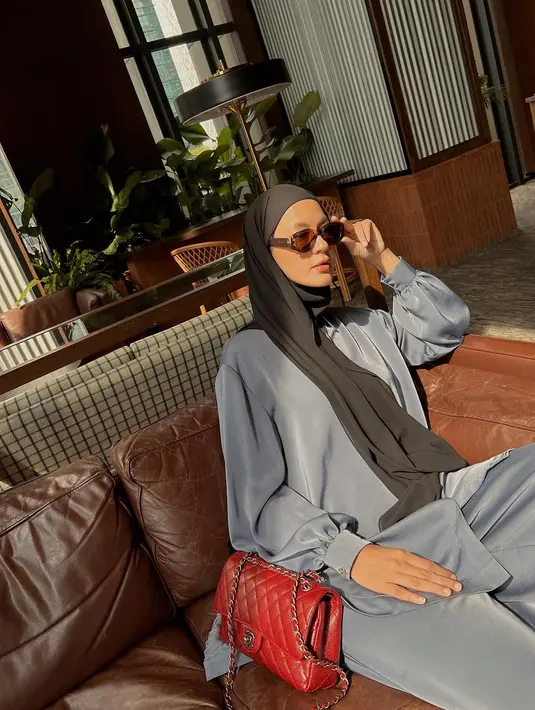Jinjing tas Chanel merah, Paula kenakan setelan kemeja dan celana abu-abu satin. Dipadu dengan hijab lilit hitam dan sunglasses [@paula_verhoeven]