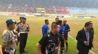 Wasit Jerry Elly dan koleganya yang memimpin pertandingan Sriwijaya FC vs Persebaya United, dijaga petugas keamaan saat aksi protes dilancarkan kubu Persebaya United. (Bola.com/Riskha Prasetya)