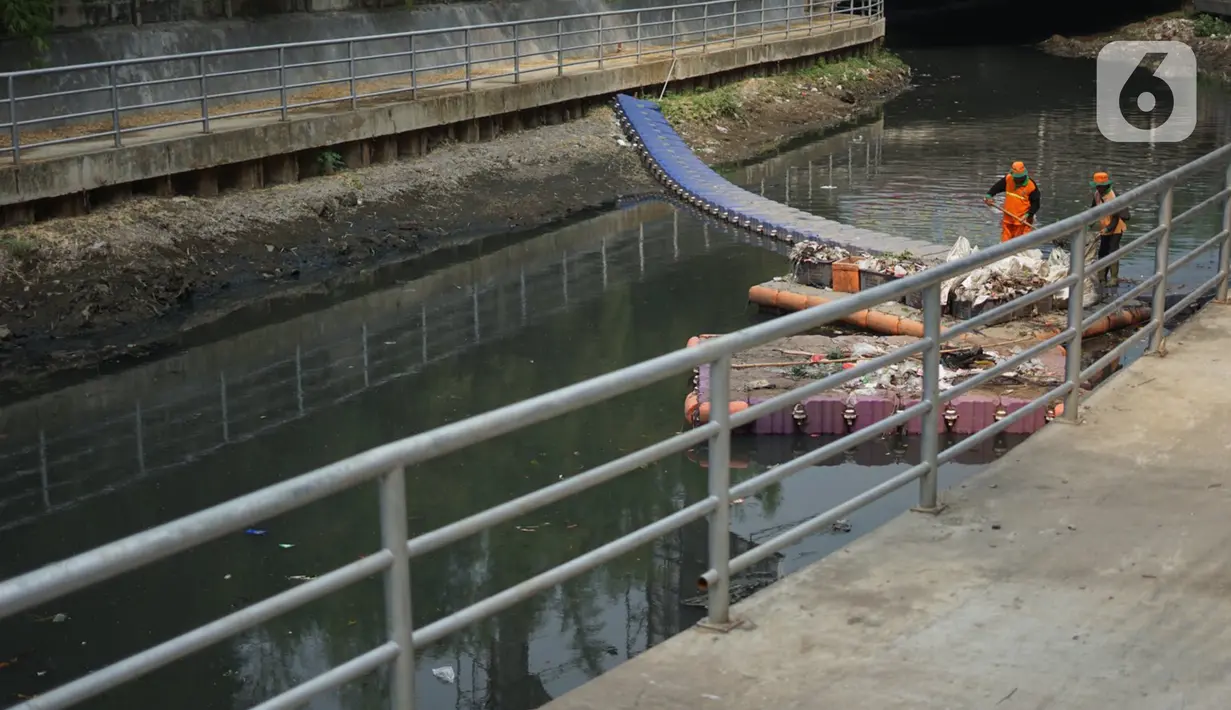 Petugas membersihkan sampah di sepanjang Kali Taman Anggrek, Jakarta, Rabu (8/7/2020). Banyaknya limbah menyebabkan Kali Taman Anggrek menjadi berwarna hitam dan berbau tidak sedap meskipun dibersihkan setiap hari. (Liputan6.com/Immanuel Antonius)