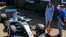 Bocah penderita kanker tulang langka Harry Shaw digendong ayahnya melihat mobil F1 yang dia terima dari Lewis Hamilton di Redhill, Surrey, Inggris, 13 Mei 2019. Mobil Mercedes dengan nomor 44 itu terparkir dengan rapih di halaman rumah Harry. (James Shaw/via REUTERS)