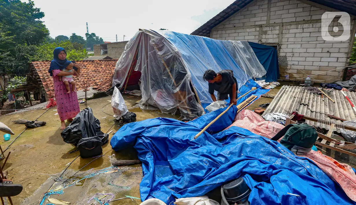 Warga beraktivitas pada tenda darurat yang dibangun di atas rumah pasca banjir melanda kawasan Pejaten Timur, Jakarta Selatan, Senin (8/1/2024). (merdeka.com/Arie Basuki)