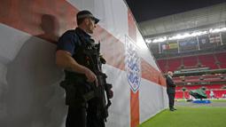 Kepolisian Inggris dengan senjata lengkap menjaga latihan timnas Prancis jelang laga ujicoba melawan Inggris di Stadion Wembley, Inggris, Senin (16/11/2015). (AFP Photo/Adrian Dennis)