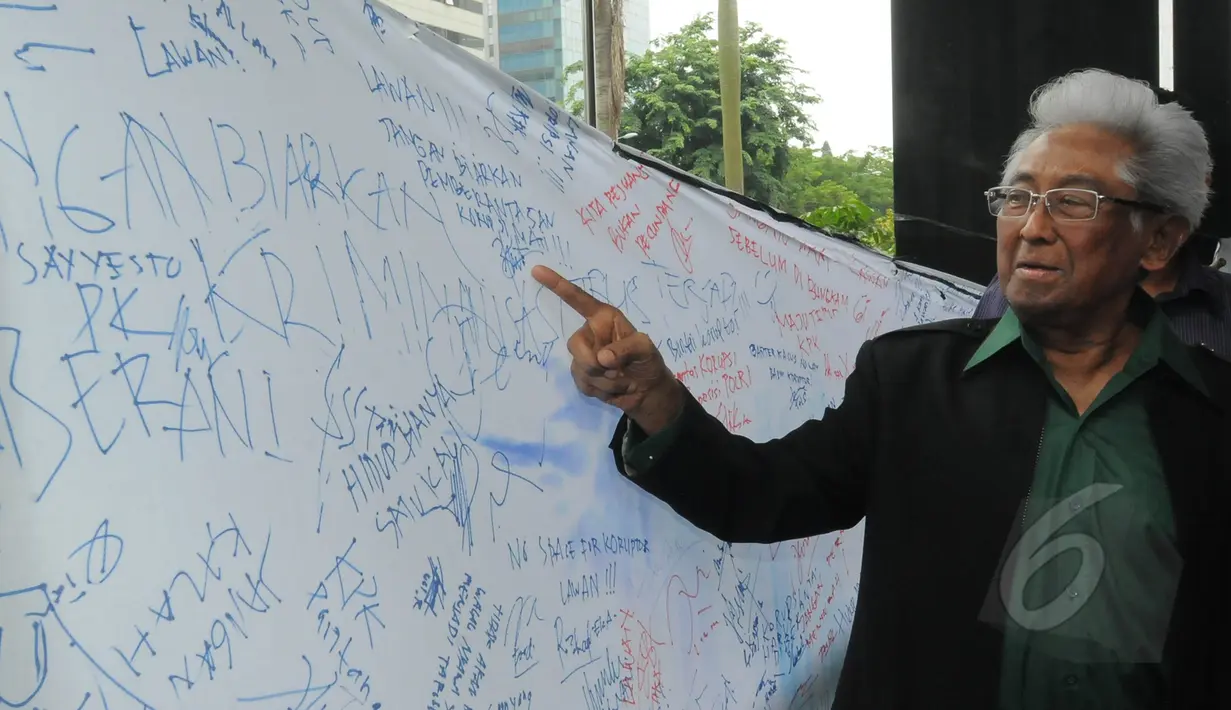 Adnan Buyung Nasution menunjuk spanduk dukungan kepada KPK, Jakarta, Jumat (6/3/2015). Adnan mengungkapkan kliennya Anas Urbaningrum akan melakukan kasasi ke Mahkamah Agung atas vonis yang diterimanya. (Liputan6.com/Herman Zakharia)