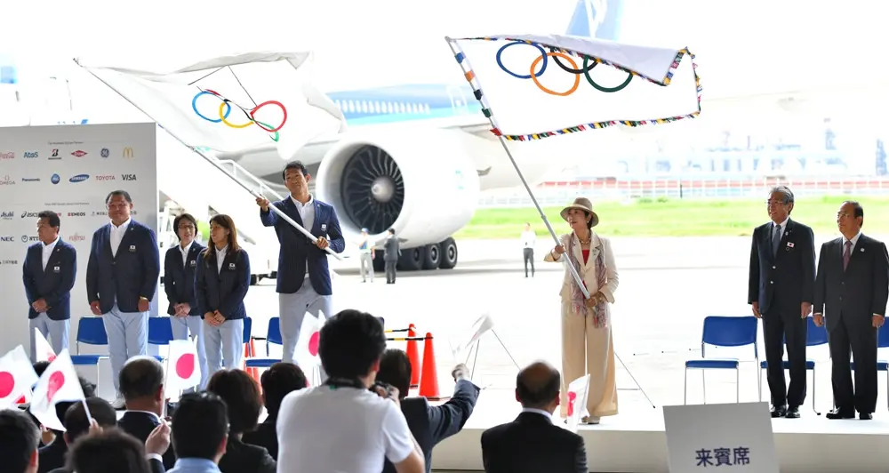 Gubernur Tokyo, Yuriko Koike (tengah) mengibarkan bendera Olimpiade, dalam acara kedatangan bendera Olimpiade