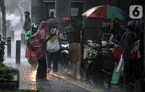 Aktivitas warga saat hujan deras di kawasan Jalan Sudirman, Jakarta, Jumat (9/12/2022). Penjabat Gubernur DKI Jakarta Heru Budi Hartono menyebut pihaknya akan mengkaji penerapan bekerja dari rumah atau work from home (WFH), hal ini berkaitan dengan arahan dari Presiden Joko Widodo atau Jokowi tentang potensi cuaca ekstrem pada penghujung 2022. (Liputan6.com/Faizal Fanani)
