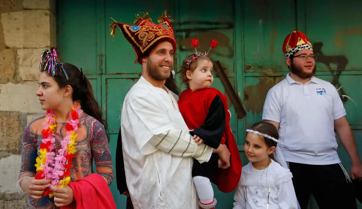 Warga Yahudi mengenakan kostum-kostum unik saat merayakan Hari Purim di Jalan al-Shuhada, Kota Hebron, Tepi Barat, Kamis (1/3). (AFP PHOTO/HAZEM BADER)