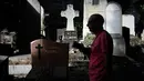 Seorang turis berjalan melewati kuburan di pemakaman Pere Lachaise di Paris (22/7/2019). Pemakaman ini jauh dari kata angker apalagi menyeramkan sebab setiap tahun ribuan bahkan jutaan wisatawan dari berbagai mancanegara berkunjung ke tempat ini. (AFP Photo/Philippe Lopez)
