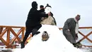 Sejumlah pria Kashmir membuat boneka salju di tepi Danau Dal setelah salju turun di Srinagar, India bagian utara, Sabtu (5/1). Wilayah Kashmir mengalami salju selama beberapa hari yang mengakibatkan terputus jalan raya Jammu-Srinagar (TAUSEEF MUSTAFA/AFP)